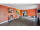Living room with terracotta walls, dark tile floors, and a view of the kitchen at 15825 Redington Dr, Redington Beach, FL 33708
