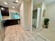 Open kitchen layout with stainless steel appliances, dark cabinets and access to the laundry room at 16543 Lake Brigadoon Cir, Tampa, FL 33618