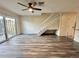 Bright living room featuring gray wood floors, a ceiling fan, and sliding glass doors to a patio at 16543 Lake Brigadoon Cir, Tampa, FL 33618