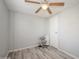 Bright bedroom featuring ceiling fan and grey wood-look floors at 233 Tarpon Ln, Oldsmar, FL 34677