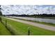 Scenic view of a canal with a paved pathway and lush greenery at 233 Tarpon Ln, Oldsmar, FL 34677