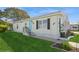 Yellow single-wide manufactured home with teal door and landscaped yard at 233 Tarpon Ln, Oldsmar, FL 34677