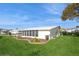 White single-wide manufactured home with covered porch and landscaped yard at 233 Tarpon Ln, Oldsmar, FL 34677