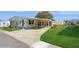 Landscaped yard with single-wide home and covered carport at 233 Tarpon Ln, Oldsmar, FL 34677