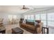 Living room with brown couch, dining table, and large windows at 233 Tarpon Ln, Oldsmar, FL 34677