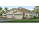 Two-story house with a three-car garage and landscaped lawn at 2383 Warren Acres Blvd, Wesley Chapel, FL 33543