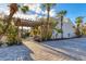 Inviting entryway with pergola, bench, and lush landscaping at 4621 Gulf Of Mexico Dr # D10, Longboat Key, FL 34228