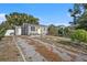 Gray house with yellow door, gravel driveway, and landscaped yard at 4809 11Th S Ave, St Petersburg, FL 33711