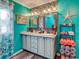 Double vanity bathroom with teal walls, and mosaic backsplash at 8624 Fantasia Park Way, Riverview, FL 33578
