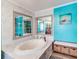 Relaxing bathroom with a large soaking tub and teal walls at 8624 Fantasia Park Way, Riverview, FL 33578