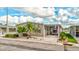 Tan mobile home with carport and nicely landscaped front yard at 8624 Fantasia Park Way, Riverview, FL 33578