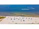 Aerial view of beach with people, umbrellas, and boats on the water at 907 Bahia Del Sol Dr, Ruskin, FL 33570