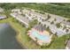 An aerial view of a townhome community with a swimming pool, pond, and lush landscaping at 12827 Buffalo Run Dr, Gibsonton, FL 33534