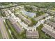 Wide aerial shot of a townhome community surrounding a pond with lush greenery at 12827 Buffalo Run Dr, Gibsonton, FL 33534