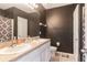 Well-lit bathroom featuring double sinks, granite countertops, and modern fixtures at 12827 Buffalo Run Dr, Gibsonton, FL 33534
