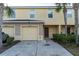 Inviting townhome featuring a one-car garage, mature landscaping, and a covered front entryway at 12827 Buffalo Run Dr, Gibsonton, FL 33534