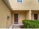 Cozy townhome front porch features a covered entryway, lush green bushes, and yellow-painted exterior at 12827 Buffalo Run Dr, Gibsonton, FL 33534