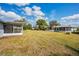 View of expansive backyard, showcasing two houses and grassy areas at 1518 W Dorchester Dr, Palm Harbor, FL 34684