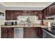 Well-equipped kitchen with dark wood cabinets and granite counters at 19029 Us Highway 19 N # 8-25, Clearwater, FL 33764