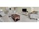 Living room with sofa, armchairs, and a view into the kitchen at 19029 Us Highway 19 N # 8-25, Clearwater, FL 33764
