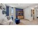 Upstairs loft area with a couch, built-in shelving, and blue accent wall at 3443 Hilltop Cir, Lakewood Ranch, FL 34211