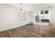 Dining room area featuring hardwood floors, a modern chandelier, and bright lighting at 4708 W Oklahoma Ave, Tampa, FL 33616