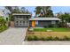 Exterior of a modern home featuring an orange front door and manicured front lawn at 4708 W Oklahoma Ave, Tampa, FL 33616