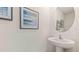 Simple bathroom with pedestal sink and framed art at 5253 Salt Marsh Rd, Wimauma, FL 33598