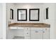 Bathroom vanity featuring granite countertop, white cabinets, brushed nickel hardware, and two decorative mirrors at 1501 Gulf Blvd # 604, Clearwater Beach, FL 33767