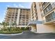 Exterior shot of a condominium building featuring a covered entryway and well-maintained landscaping at 1501 Gulf Blvd # 604, Clearwater Beach, FL 33767