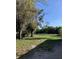 Fenced backyard with open grassy area and mature trees at 37210 Bermont Rd, Punta Gorda, FL 33982