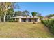 Large backyard with grassy area and screened patio at 970 Rolling Hills Dr, Palm Harbor, FL 34683