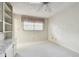 Bright bedroom featuring a window with blinds and ceiling fan at 970 Rolling Hills Dr, Palm Harbor, FL 34683