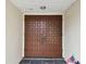 Double wood doors with a grid pattern open to the foyer at 970 Rolling Hills Dr, Palm Harbor, FL 34683