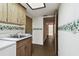 Laundry room with sink, cabinets, and access to other areas at 970 Rolling Hills Dr, Palm Harbor, FL 34683