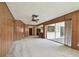 Bright living room featuring wood paneling and access to the patio at 970 Rolling Hills Dr, Palm Harbor, FL 34683