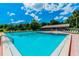 Community pool area with a spacious deck and trees at 970 Rolling Hills Dr, Palm Harbor, FL 34683