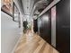 Long hallway with light walls, hardwood floors, and modern black doors at 101 N 12Th St # 207, Tampa, FL 33602