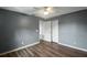 Bedroom with gray walls, wood-look floors, ceiling fan, and access to another room at 10212 Grant Creek Dr, Tampa, FL 33647