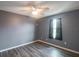 Bright bedroom with grey walls, wood-look flooring, and ceiling fan at 10212 Grant Creek Dr, Tampa, FL 33647