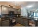 Modern kitchen with gray cabinets, black countertops, and stainless steel appliances at 10212 Grant Creek Dr, Tampa, FL 33647