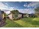 Landscaped backyard with a grassy area and mature trees at 11976 Blazing Star Dr, Venice, FL 34293