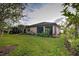 Backyard view showcasing a large grassy area and screened enclosure at 11976 Blazing Star Dr, Venice, FL 34293