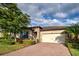 House exterior featuring a brick driveway and lush landscaping at 11976 Blazing Star Dr, Venice, FL 34293