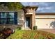 House exterior with stone accents, landscaping, and a two-car garage at 11976 Blazing Star Dr, Venice, FL 34293