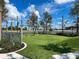 Wooden swing set in fenced playground with artificial turf at 11976 Blazing Star Dr, Venice, FL 34293