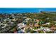 Aerial view of a coastal neighborhood featuring lush foliage and blue ocean water in the distance at 1612 Sunset Dr, Tarpon Springs, FL 34689