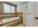 Relaxing bathroom with a large soaking tub, tile surround and window at 1612 Sunset Dr, Tarpon Springs, FL 34689