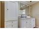 Bathroom features a white double vanity with marble countertop and large mirror at 1612 Sunset Dr, Tarpon Springs, FL 34689
