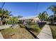Charming home with tropical landscaping, black metal fence, and stone accents at 1612 Sunset Dr, Tarpon Springs, FL 34689